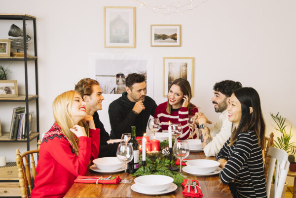 Couple and friends gather at a dinner party to visit